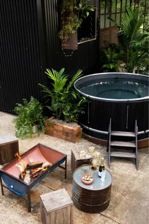 The heated magnesium plunge pool beside a fire pit, set in tropical greenery