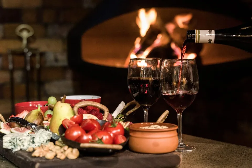 the suspended fire, a wine, a platter — stay a while